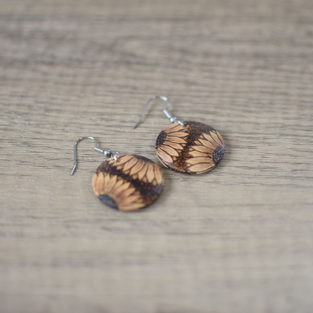 phot of wooden drop earrings with a double sunflower design