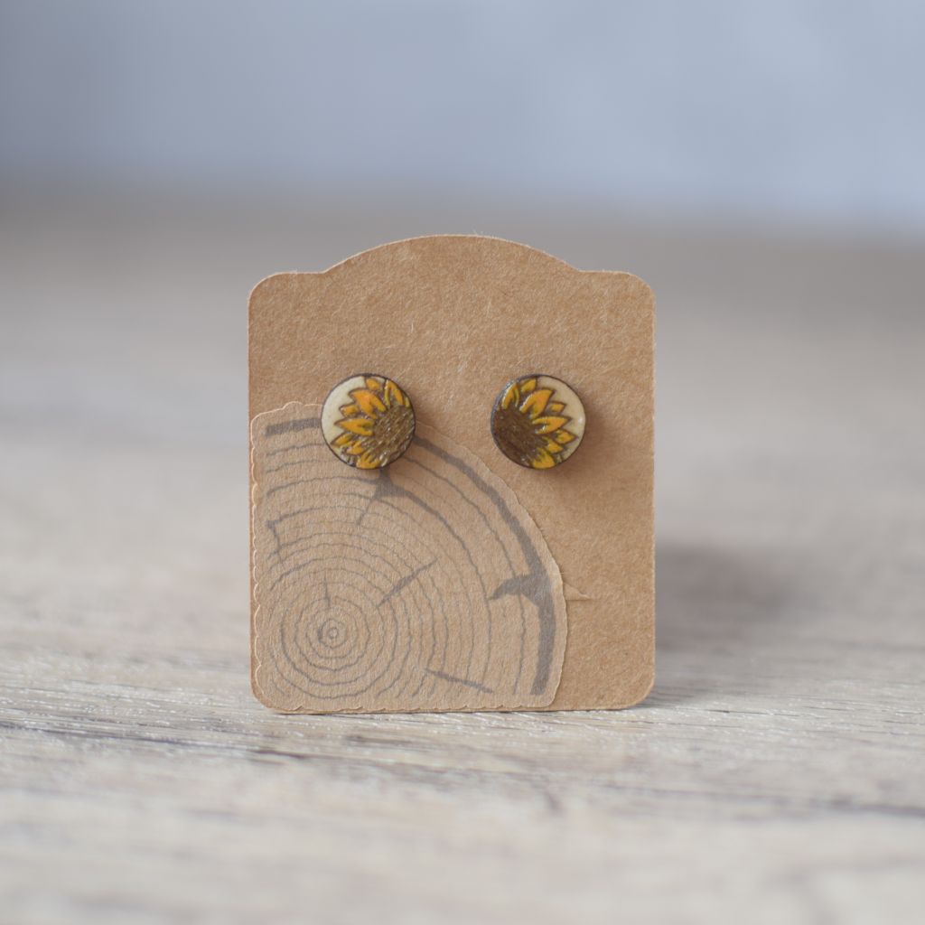 Photos showing Sunflower Stud earrings with sunflower design on a kraft card backing