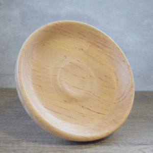 A light coloured shallow wooden decorative dish