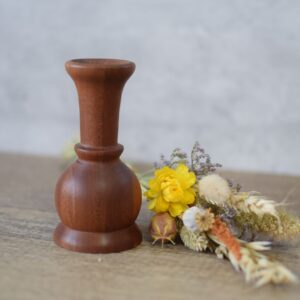 a small Sapele twig vase next to a posy of dried wild flowers