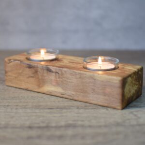 phot showing a wooden spalted beech tealight holder with two glass inserts, candles are lit.