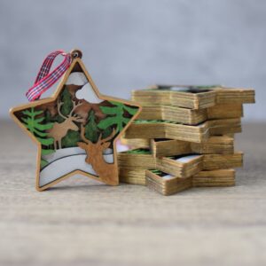 wooden laser cut layered star decoration with a deer scene and finished with a tartan ribbon to hang