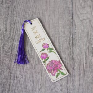 a photo showing a wooden laser engraved bookmark with a hand painted pink flower design
