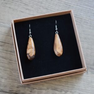 A pair of Olive wood tear drop shape earrings mounted on a black velvet style backing in a kraft card gift box